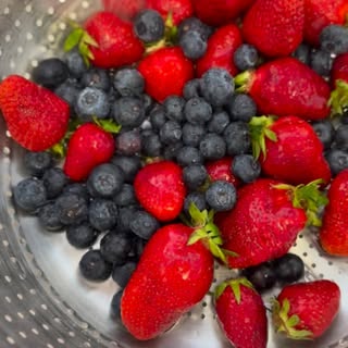 Frische Erdbeeren und Heidelbeeren in einem Sieb, frisch gewaschen.